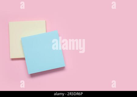 Sticky notes on pale pink background Stock Photo