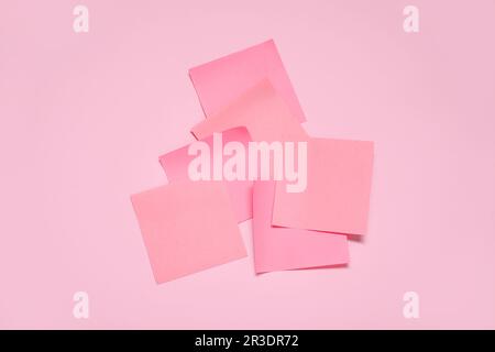 Sticky notes on pale pink background Stock Photo