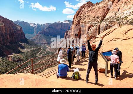 Asian man stretching. Tourists & hikers at top of Canyon Overlook Trail; Zion National Park; Utah; USA Stock Photo