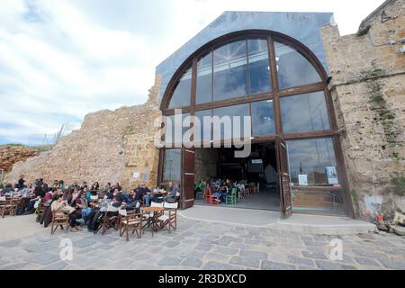 People sitting outside Chania fish taverna, old Venetian Neoria, Chania, Crete, Greece, Europe Stock Photo