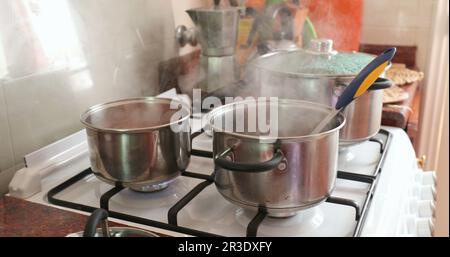 Cooking food, steam coming out from pans and pots Stock Photo