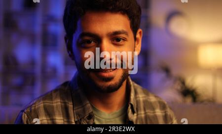 Gorgeous portrait of attractive confident Arabian man with toothy smile looking at camera in modern living room. Businessman posing in casual stylish Stock Photo