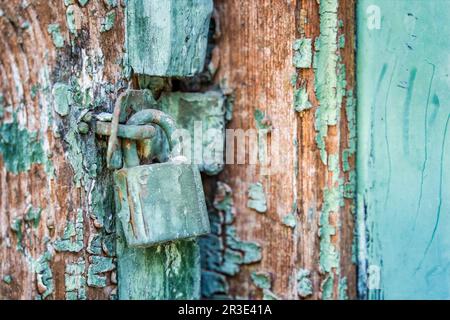 Old rusted padlock on a blue wooden door Stock Photo