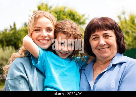 Cute girl embracing mother and grandmother outdoors Stock Photo