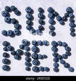 Summer inscription lined from blueberries. Fruits and berries, vegetarian and healthy eating concept. Summer text created from b Stock Photo