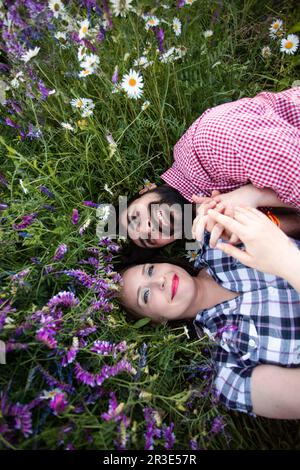 Romantic couple love moment in field among wild flowers Stock Photo