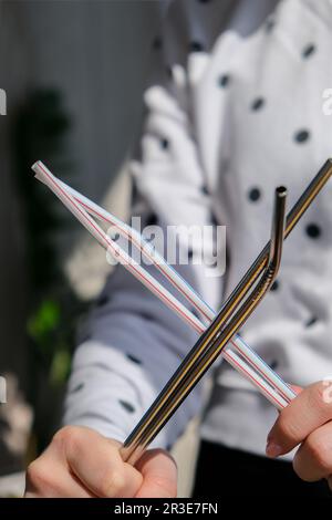 Woman holding Reusable Metal and plastic drinking Straws. Female Hand on reusable collapsible drinking straw. Eco lifestyle and Stock Photo