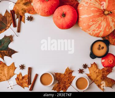 Autumn food. Frame of pumpkin puree soup, leaves. Top view. Autumn harvest, pumpkins, leaves on grey as abstract background. Tha Stock Photo