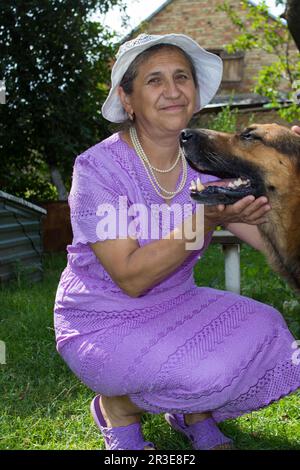 smiling retirement woman with german shepherd in countryside Stock Photo