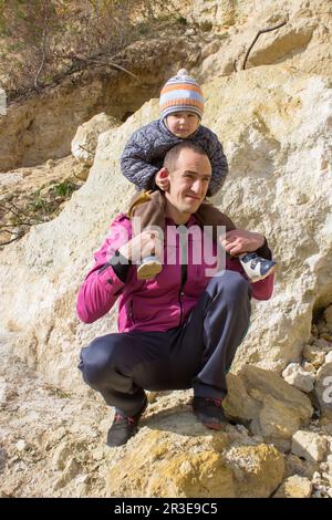 happy family in the sandy mountains, the son sits on his father's neck Stock Photo