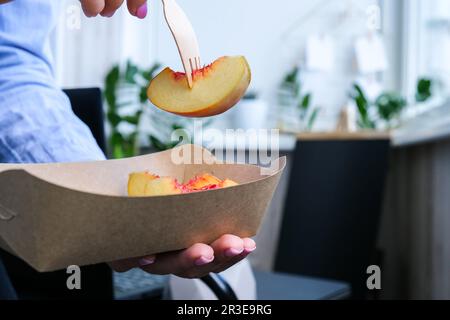 Businesswoman having a healthy lunch break from delivered eco lunch boxes. Delicious balanced food concept. Home office. Eco tab Stock Photo