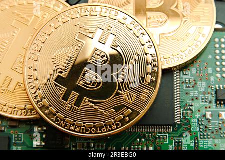 Conceptual cryptocurrency bitcoins on a computer motherboard Stock Photo