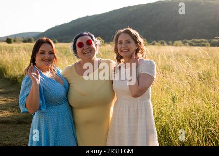 The happy girlfriends are hugging in nature Stock Photo