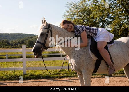 The young woman spends time with her favorite horse Stock Photo