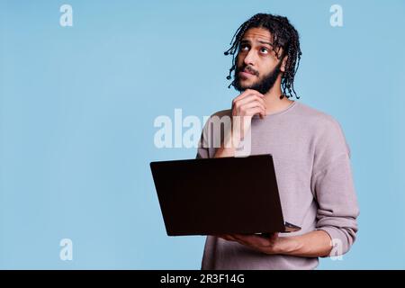 Arab man reading programming report on laptop Stock Photo