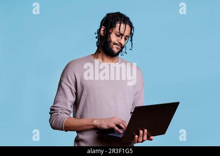 Thoughtful man analyzing software development while working on laptop Stock Photo