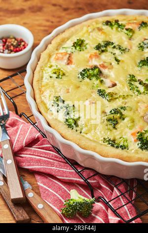 Homemade quiche with red fish, salmon, broccoli and cheese on wooden background Stock Photo
