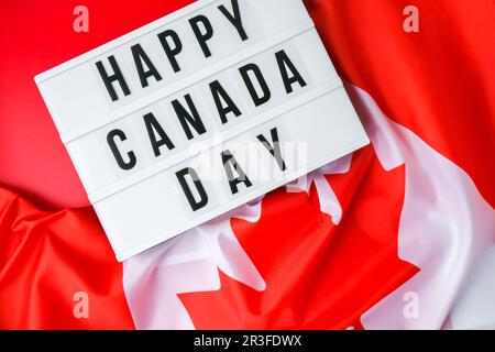 The National Flag of Canada. Lightbox with text HAPPY CANADA DAY Canadian Flag or the Maple Leaf. Patriotism. International rela Stock Photo