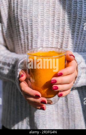 Unrecognizable woman holding Pumpkin smoothie spiced latte. Autumn coffee with spicy pumpkin flavor seasonal hot drink. Fall Dri Stock Photo