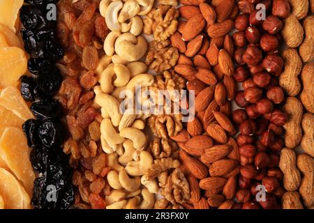 Mix of delicious dried nuts and fruits as background, top view Stock Photo