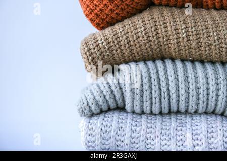 Stack of cozy knitted warm sweater. Sweaters in retro Style. Orange and blue colors. Cozy hygge concept Copy space Stock Photo