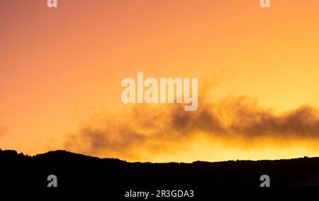 Cumulus and Stratus clouds in dramatic sunset sky Stock Photo
