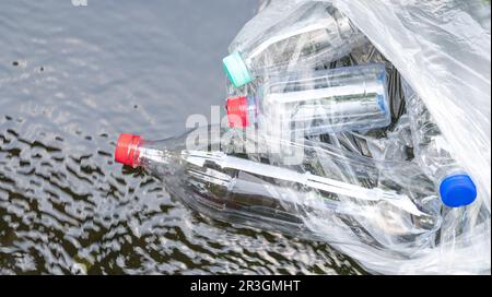 Plastic bottles floating on water surface. Pollution or trash concept. Stock Photo
