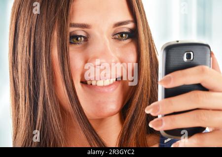 Smiling young woman using smartphone. Selfie Stock Photo