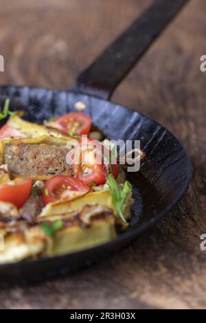 Swabian Maultasche with onions in an iron pan Stock Photo