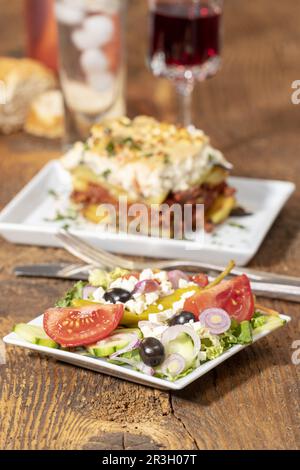 Greek salad with moussaka on wood Stock Photo