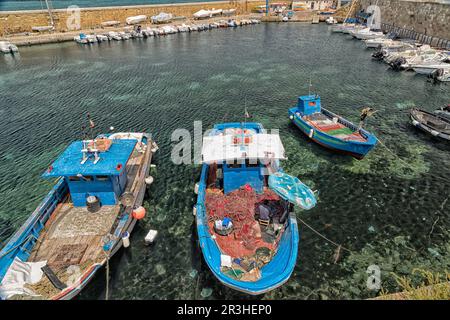 Fisherman repairs his net on boat Stock Photo