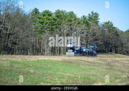 Classic blue big rig car hauler industrial semi truck tractor transporting vehicles on the modular two level semi trailer driving on the road on the h Stock Photo