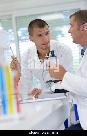male laboratory examines water under a microscope Stock Photo