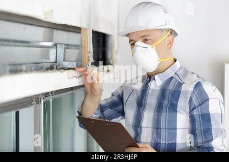construction worker checking thermally insulating walls Stock Photo