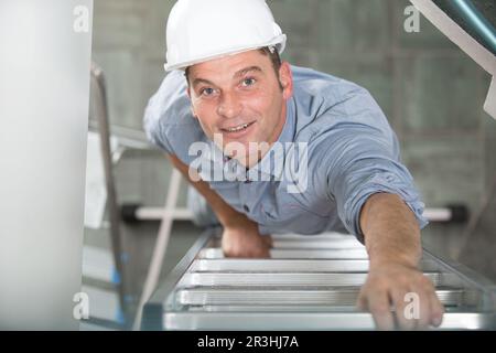man going front on high ladder Stock Photo