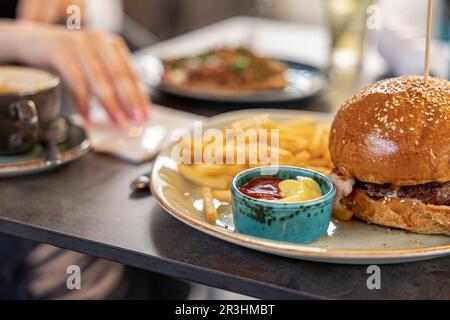 tasty delicious home made burgers with french fries and sauces Stock Photo