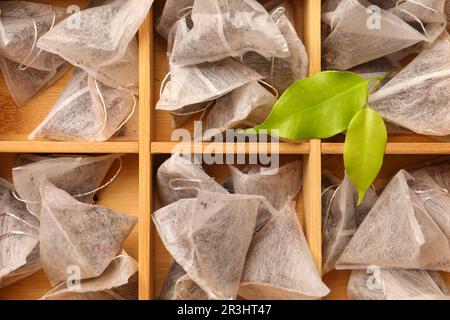 Many tea bags in wooden box as background, top view Stock Photo