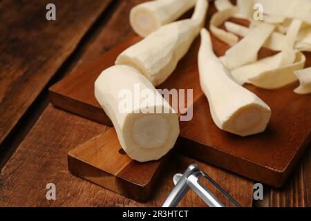 Whole and cut fresh ripe parsnips on wooden table, closeup Stock Photo