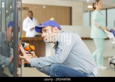 male worker with a drill in hospital Stock Photo
