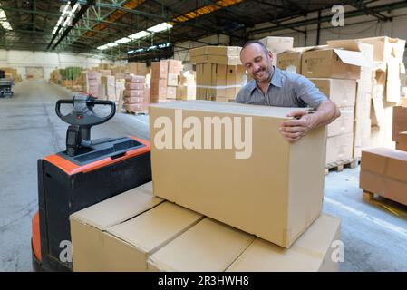 porter carrying boxes in a warehouse Stock Photo