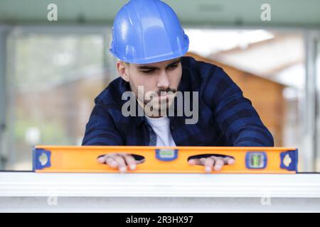 tradesman using a bubble level on a wall Stock Photo