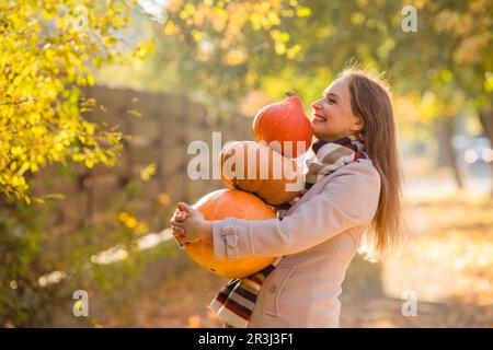 Portrait of happy smile woman with pumpkins in hand. Stock Photo