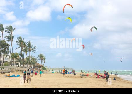 Crowd of active sporty people enjoying kitesurfing holidays and activities on perfect sunny day on Cabarete tropical sandy beach in Dominican Republic Stock Photo