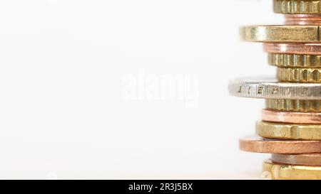 Piled up euro coins on table with white background and copy space on left side Stock Photo