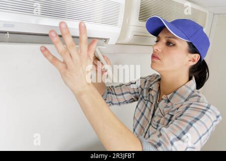 woman repairing air conditioning unit Stock Photo