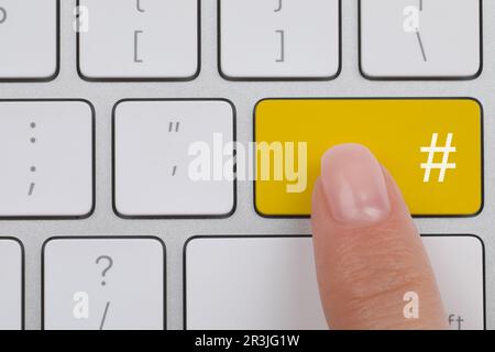Woman pressing yellow button with hashtag sign, top view Stock Photo