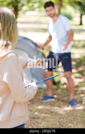 couple playing badminton by their tent Stock Photo