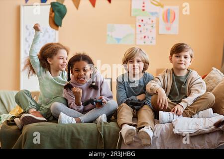 Portrait of cute black girl winning videogame over boys while playing with friends Stock Photo