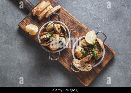 Two pan witn clams in white wine with herbs. Top view Stock Photo