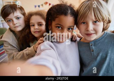 POV diverse group of happy children taking selfie photo together and smiling at camera Stock Photo
